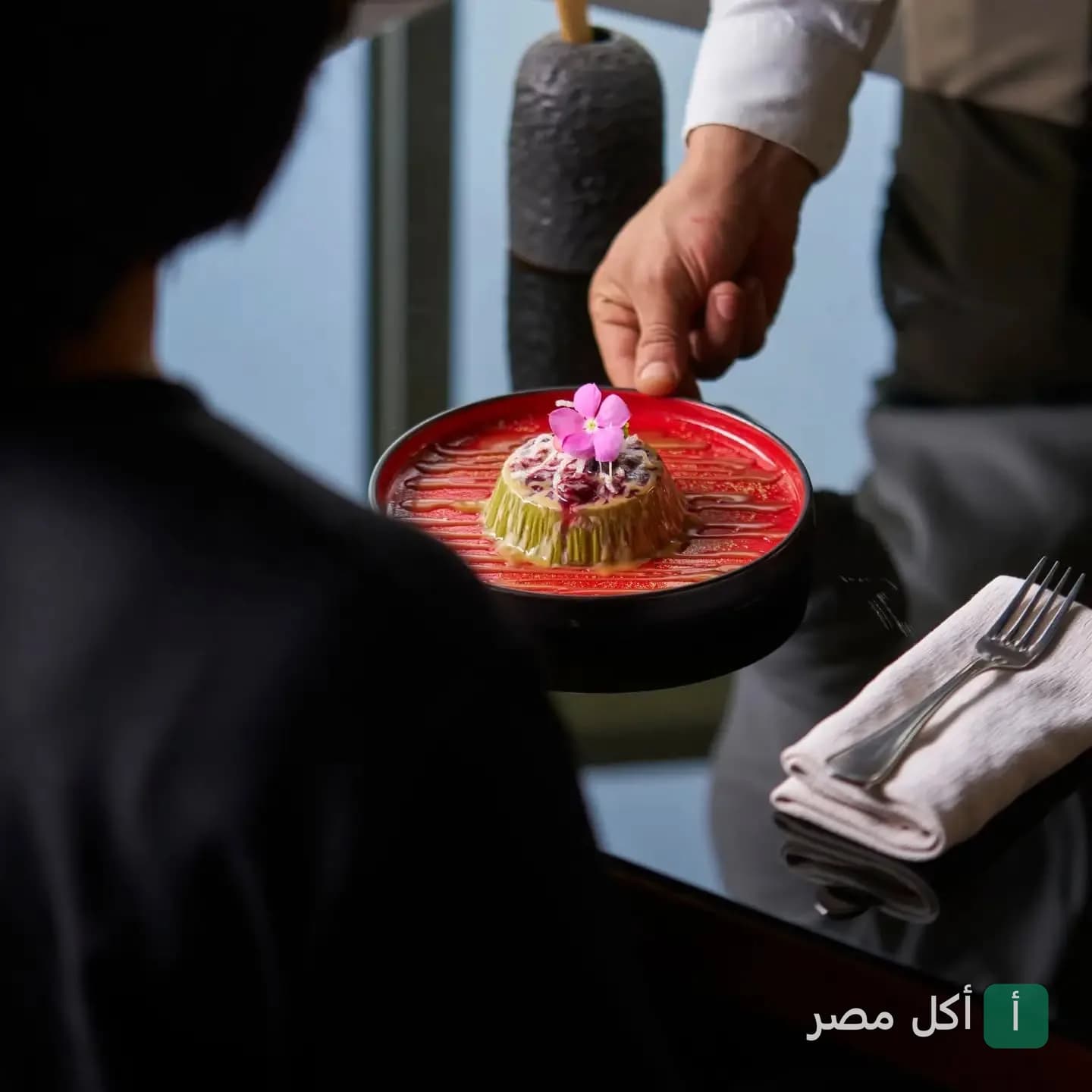 تقديم طبق حلوى مزين بوردة في مطعم نايرُو بالجيزة.