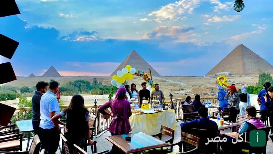 جلسة خارجية في مطعم وكافيه الهضبة بنزلة السمان مع إطلالة مباشرة على أهرامات الجيزة.