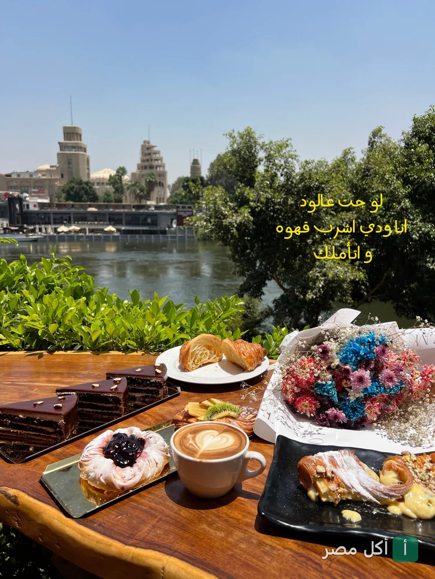 طاولة كافيه ستاج في الدقي عليها حلويات وقهوة مع إطلالة مباشرة على النيل.