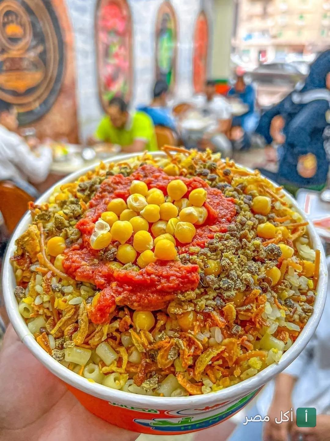 طبق كشري مصري غني بالحمص والصلصة من مطعم كشري وبيتزا هند في الجيزة.