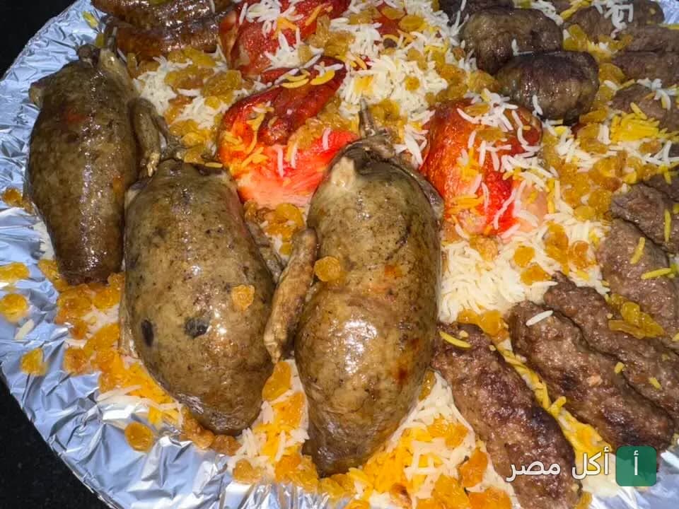 صينية مشاوي مشكلة تضم حمام محشي وكفتة ودجاج على أرز بسمتي في مطعم حضرموت البحر الأعظم بالجيزة.