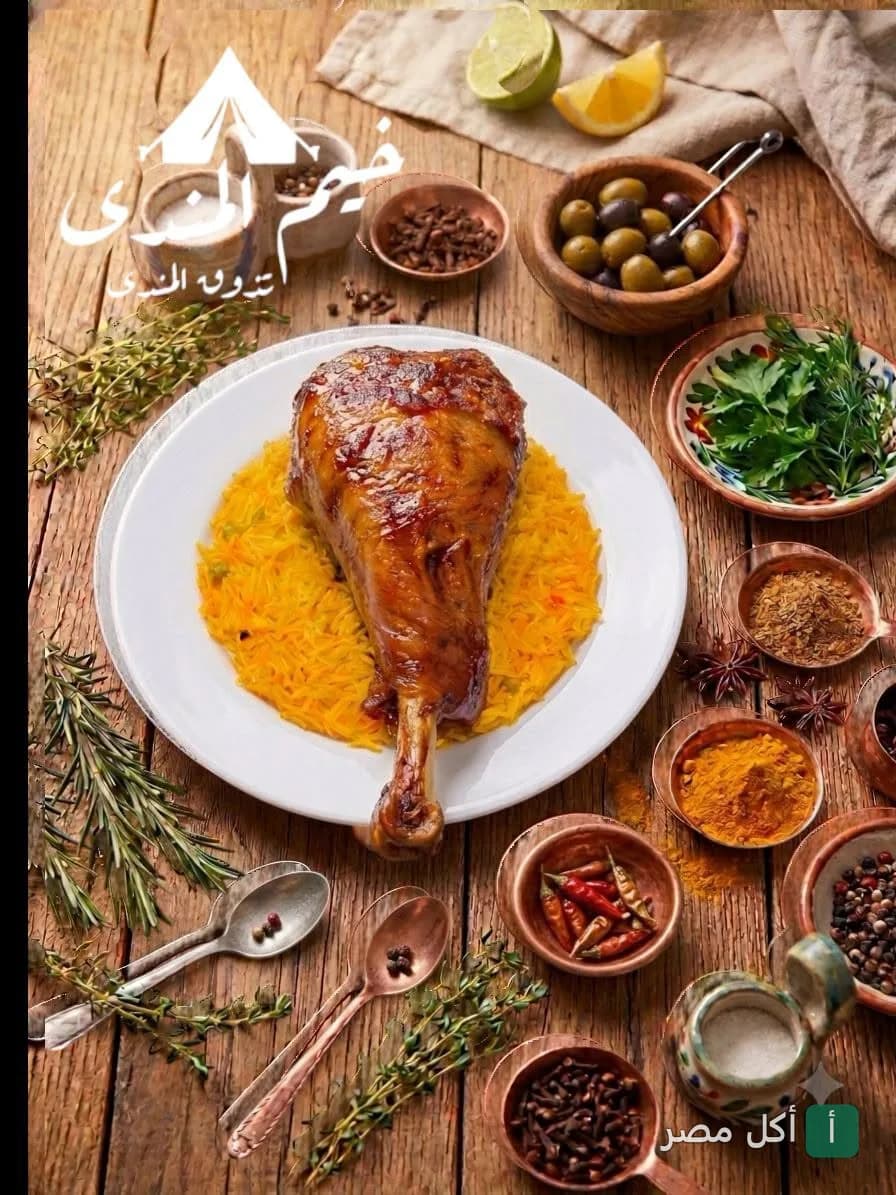 طبق مندي لحم يقدمه مطعم خيم المندي في الجيزة على طاولة خشبية مزينة بالتوابل والأعشاب.