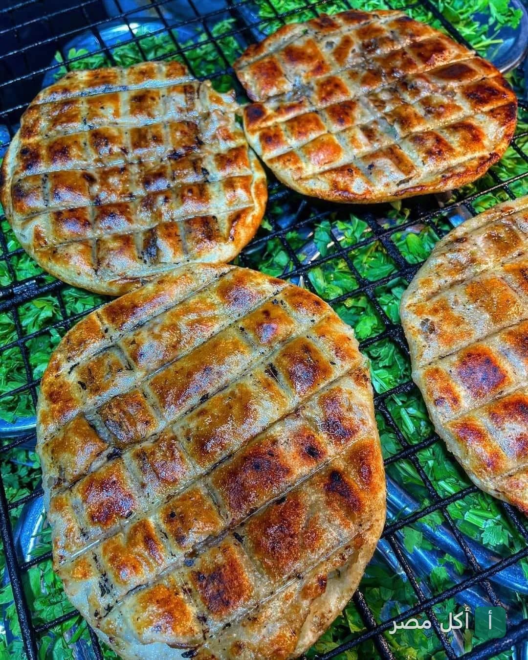 أرغفة حواوشي مشوية على الفحم في مطعم كبابجي البركة بالعمرانية الشرقية، الجيزة.