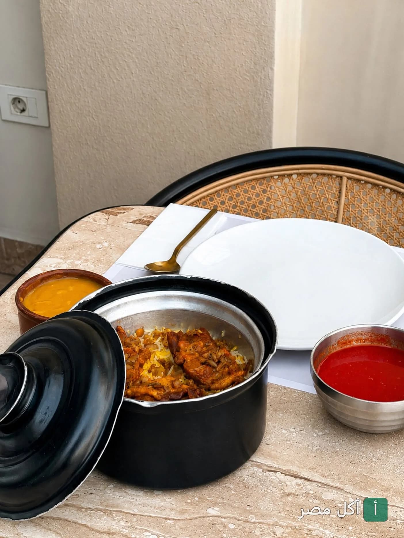 طبق أرز شرقي مع اللحم في قدر أسود مع أطباق جانبية من مطعم دار نوره في الدقي بالجيزة.
