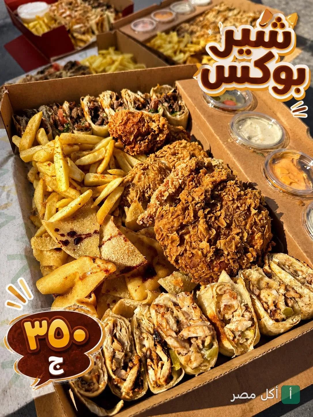 صندوق مشاركة من مطعم باب شرقي بالدقي يحتوي على قطع دجاج مقرمش، شاورما، وبطاطس محمرة مع صوصات متنوعة.
