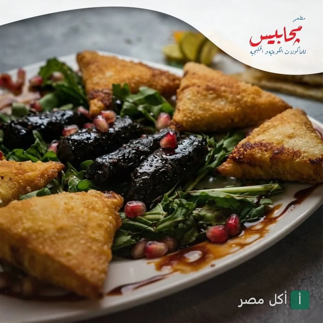 طبق مقبلات كويتي يحتوي على سمبوسة وورق عنب مزين بحبات الرمان في مطعم مجابيس بالدقي