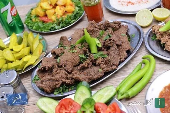 طبق كبدة مقلية يقدم مع المخللات والخضروات في مطعم الشرقاوي بترسا، الجيزة.