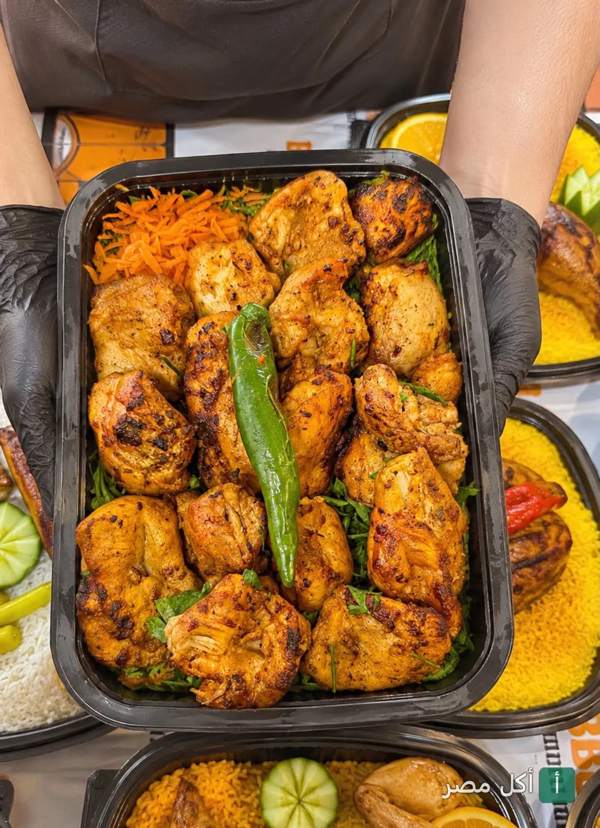 علبة وجبة دجاج مشوي متبل مع أرز في مطعم دار اليمن بفيصل، الجيزة.