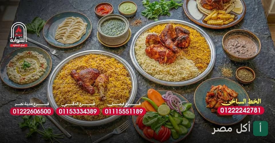 سفرة عامرة بأطباق الأرز والمشاوي اليمنية من مطعم بيت الشواية في فيصل، مع مقبلات متنوعة وسلطات.