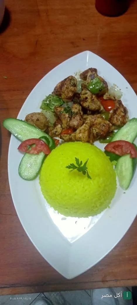 طبق دجاج مشوي مع أرز أصفر وخضروات طازجة في تري كافيه بالعمرانية، الجيزة.