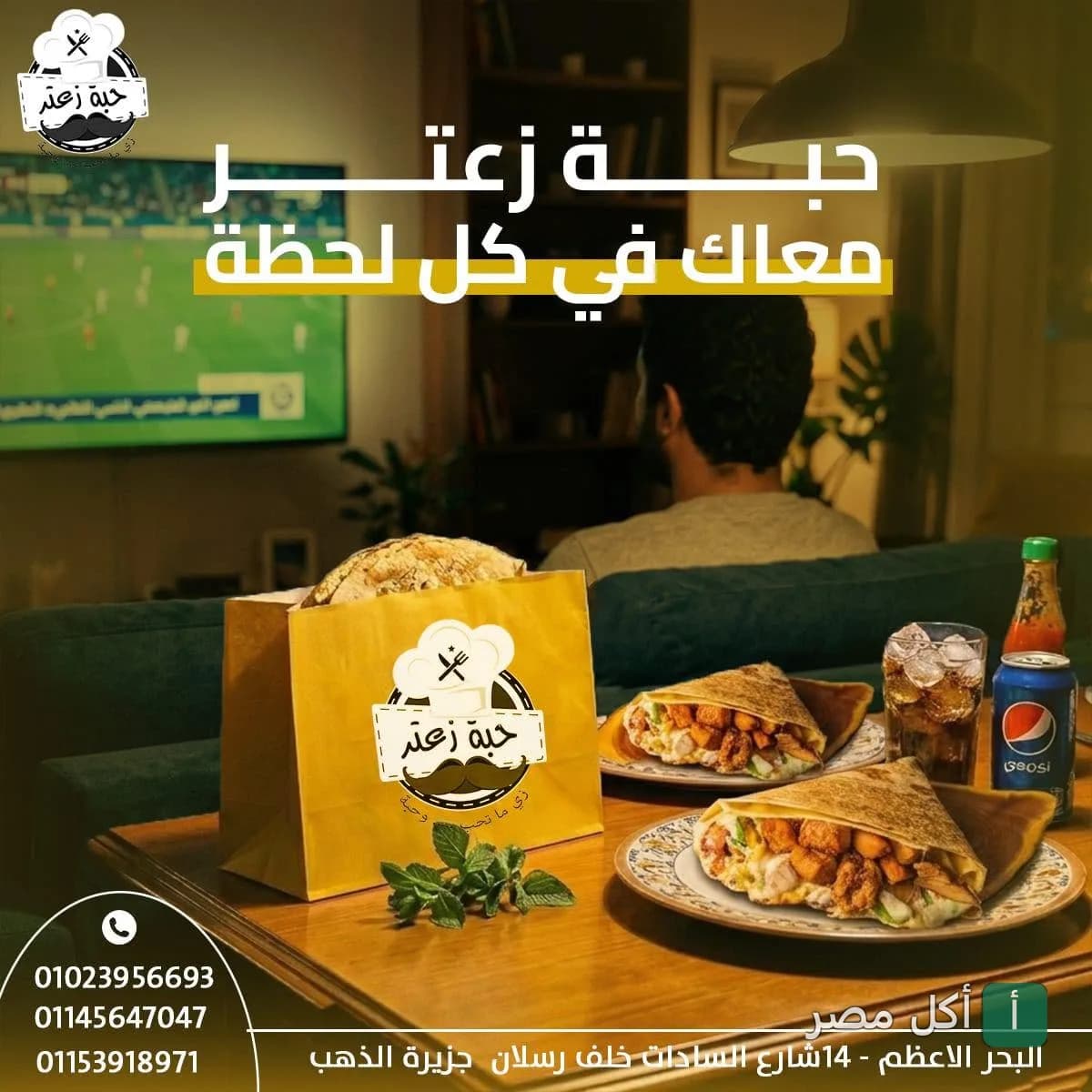 وجبات سريعة من مطعم حبة زعتر في المعتمدية بالجيزة معروضة على طاولة أمام شاشة تلفزيون.
