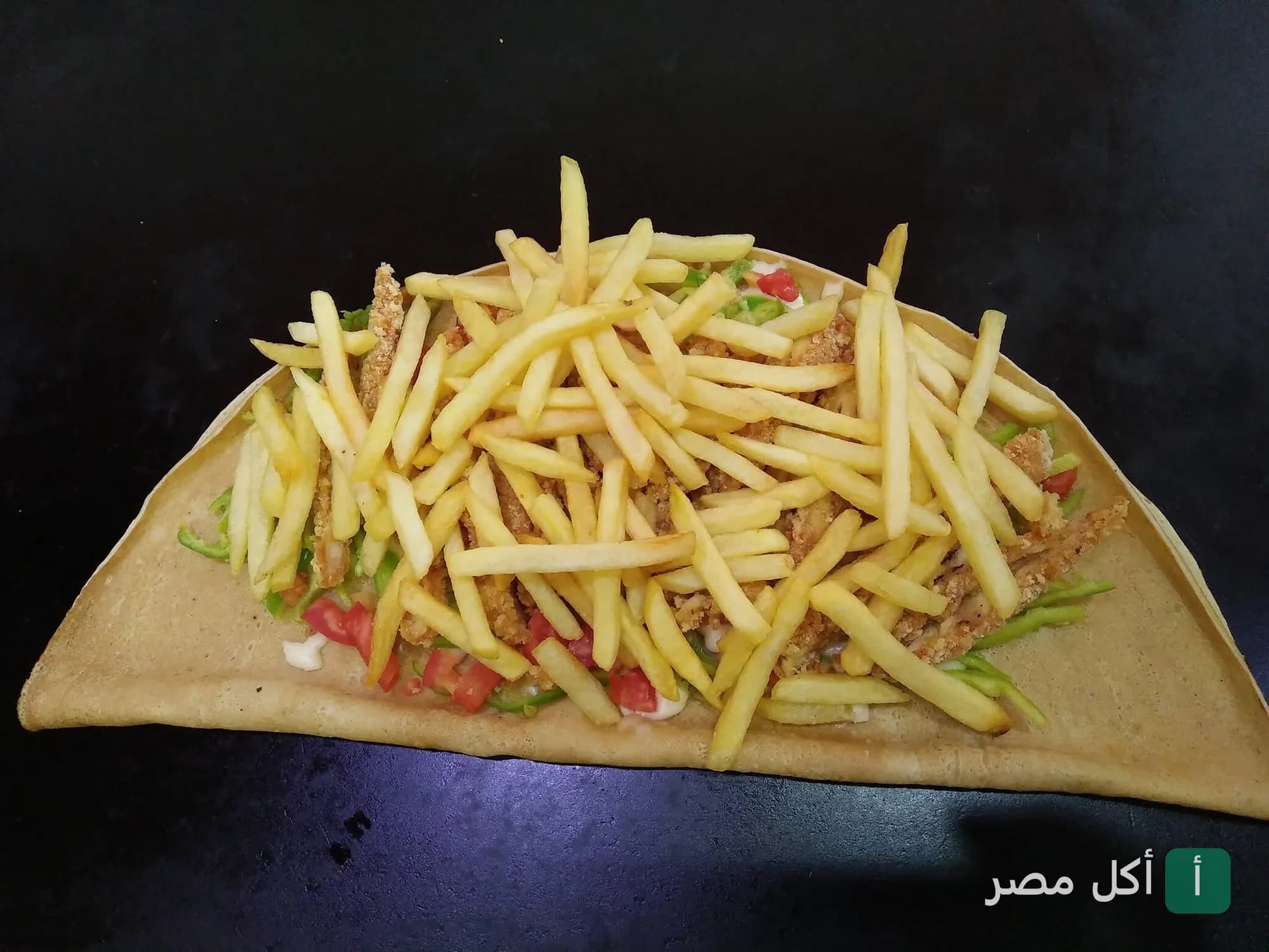 ساندوتش كريب محشو بالدجاج المقرمش والبطاطس المقلية من مطعم كريب أفندينا في فيصل بالجيزة.