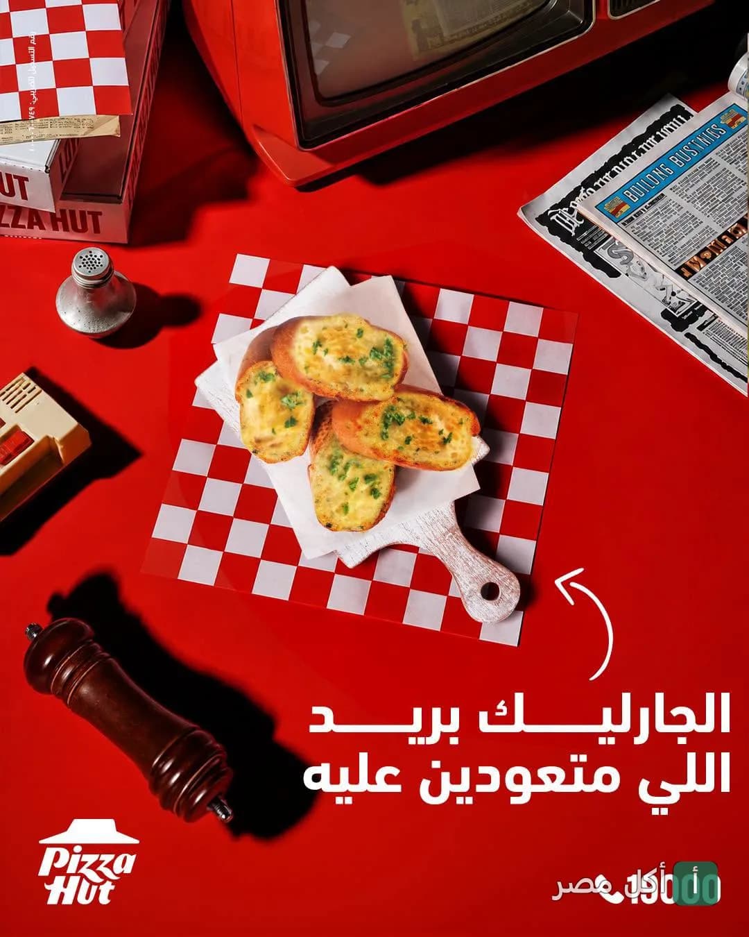 قطع خبز بالثوم على لوح تقديم خشبي صغير في مطعم بيتزا هت بمراد، الجيزة.