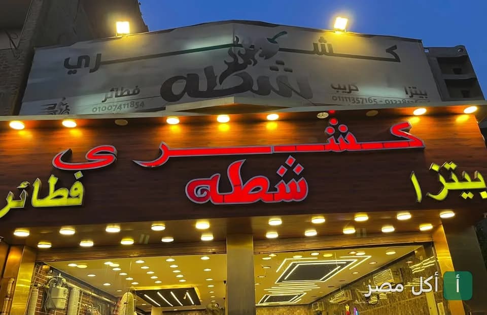 واجهة مطعم كشري شطة في بشتيل بالجيزة مع لافتة مضيئة تعرض اسم المطعم.