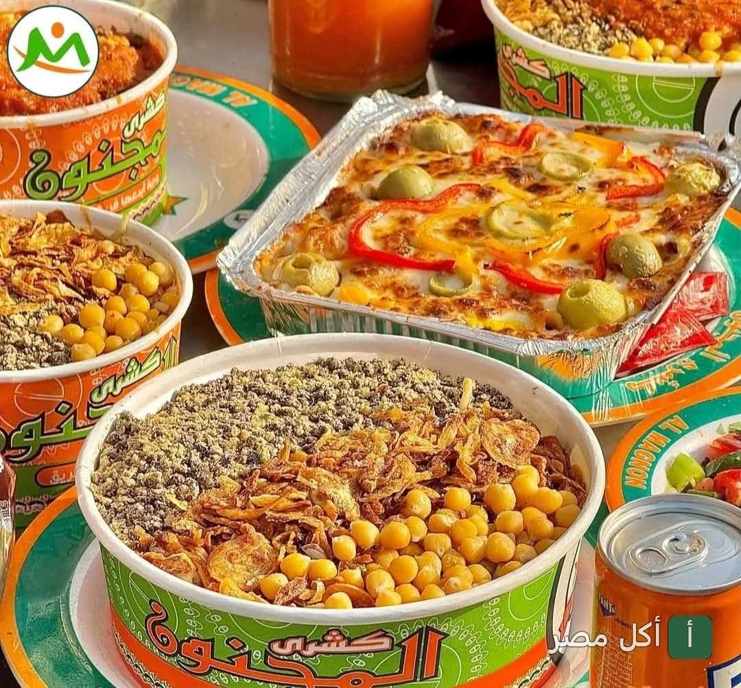 تشكيلة من أطباق كشري المجنون في إمبابة، تشمل علب كشري بالدقة والتقلية وطبق طاجن بالجبنة والزيتون.