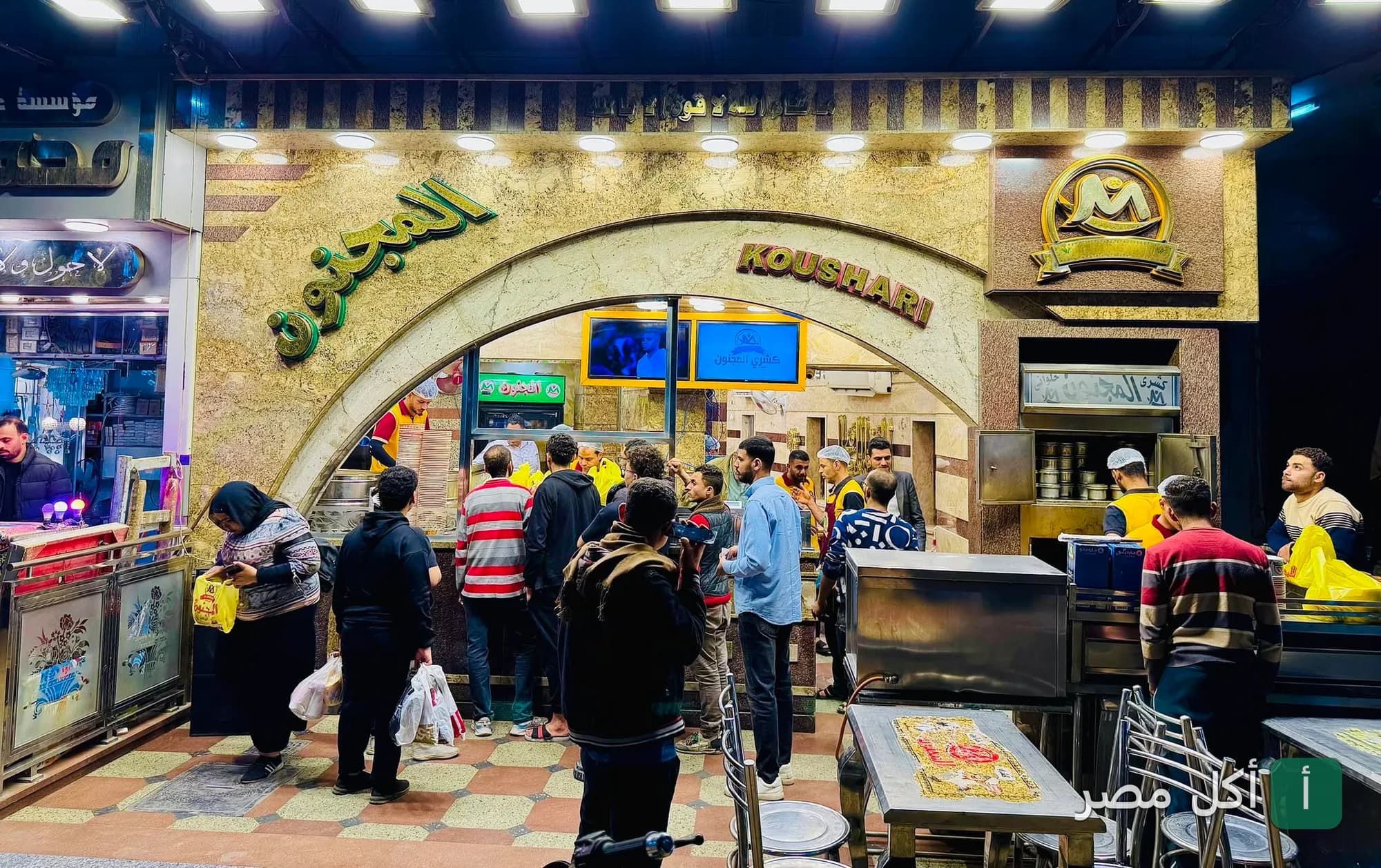 واجهة مطعم كشري المجنون في وراق العرب بإمبابة، تظهر الزبائن ينتظرون طلباتهم أمام المحل.