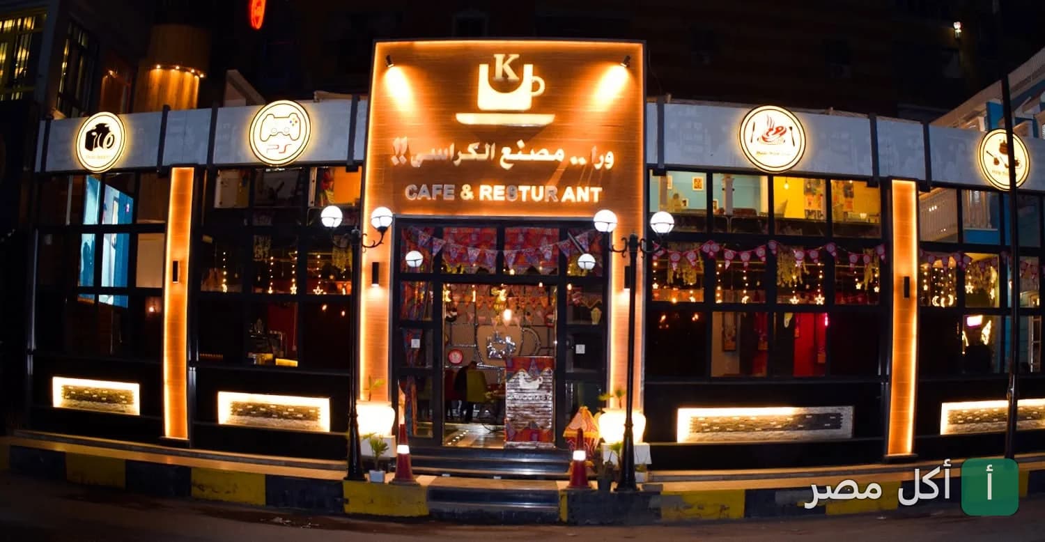 واجهة مطعم وكافيه ورا مصنع الكراسي في وراق العرب بإمبابة ليلاً مع إضاءة دافئة.