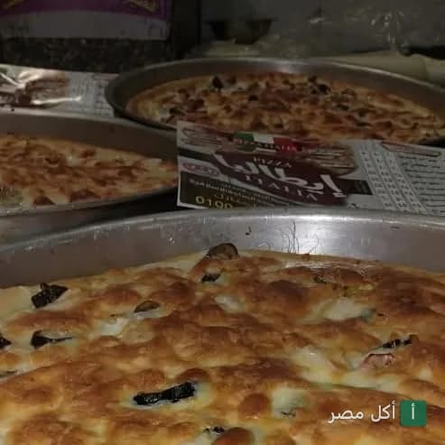 صواني بيتزا طازجة في مطعم بيتزا وفطاير ايطاليا بمدينة التحرير في إمبابة.