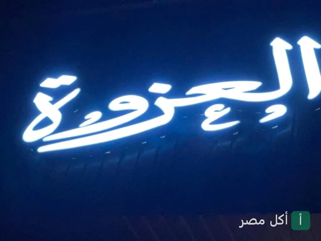 يافطة مضيئة باسم العزوة كافيه في مدينة العمال بإمبابة.
