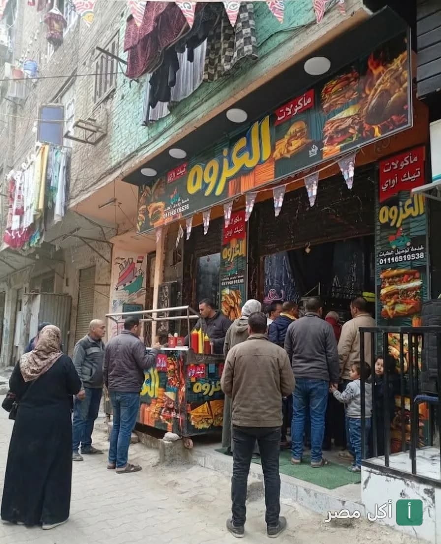 واجهة مطعم العزوه في منطقة حسين مهران بإمبابة، يظهر زبائن ينتظرون أمام المطعم.