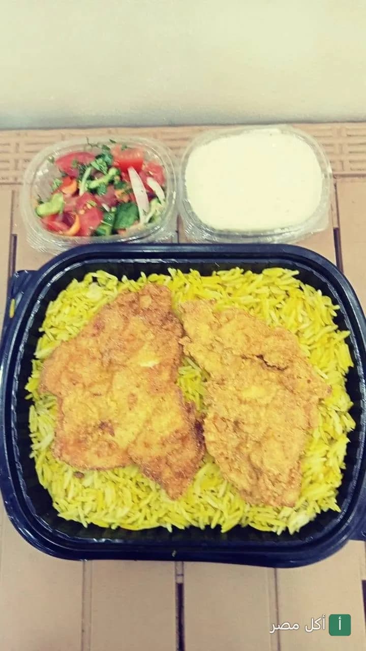 وجبة أرز أصفر مع قطع مشويات من كبابجي سرور في إمبابة، تقدم مع سلطة وطحينة.