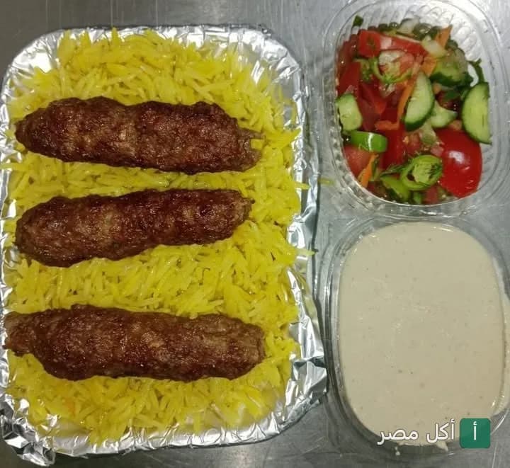 وجبة كباب مشوي على أرز أصفر مع سلطة خضراء وطحينة من كبابجي سرور في إمبابة.