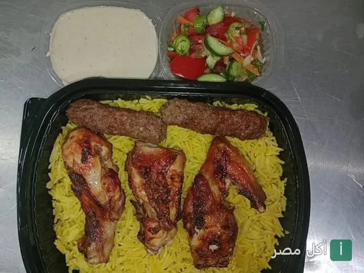 وجبة مشاوي من كبابجي سرور في إمبابة، تتكون من قطع دجاج مشوي وكفتة مع أرز أصفر وسلطة وطحينة.