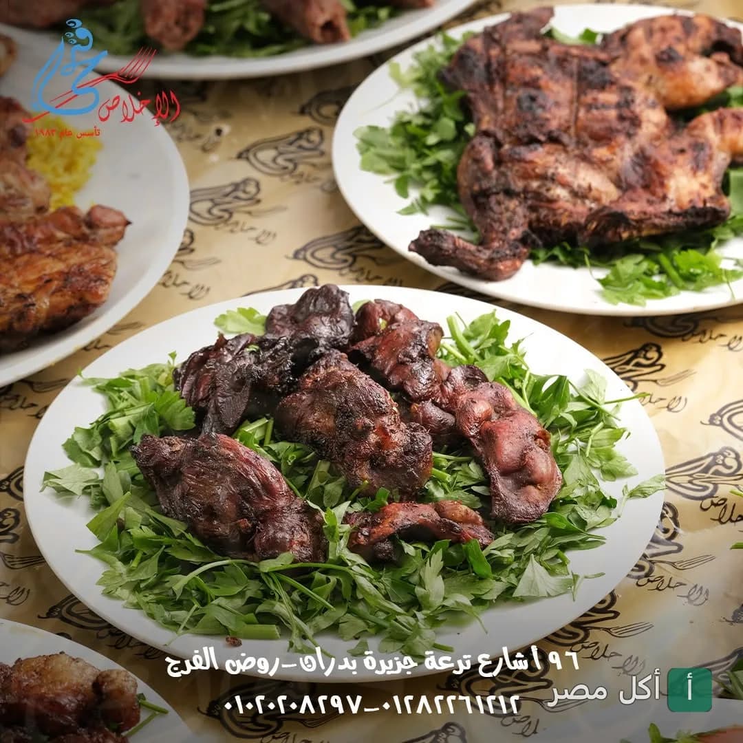 أطباق مشويات متنوعة من مطعم الإخلاص فتحي في إمبابة، تضم دجاج مشوي وكبدة على فرشة من البقدونس.