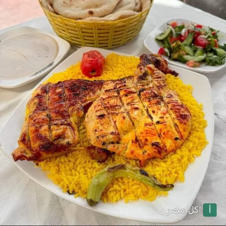 طبق دجاج مشوي على الأرز الأصفر مع سلطة وخبز في مطعم كبابجي الصفا والمروة بإمبابة.