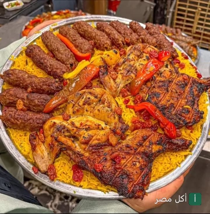 صينية مشويات متنوعة من كبابجي الصفا والمروة في إمبابة، تحتوي على كفتة ودجاج مشوي مع أرز أصفر.