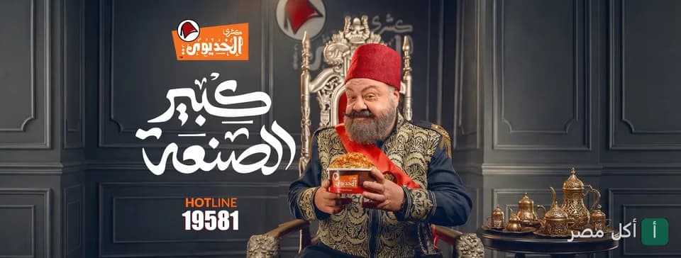 شخصية الخديوي بزي تراثي وطربوش يمسك علبة كشري الخديوي في إعلان مطعم كشري الخديوي بالمنيرة في إمبابة.