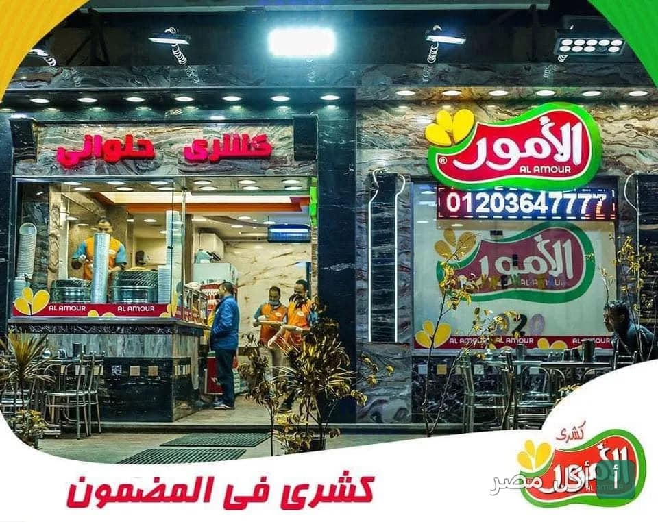 واجهة مطعم كشري الأمور في إمبابة، يظهر الموظفون داخل المحل مع لافتة العلامة التجارية.