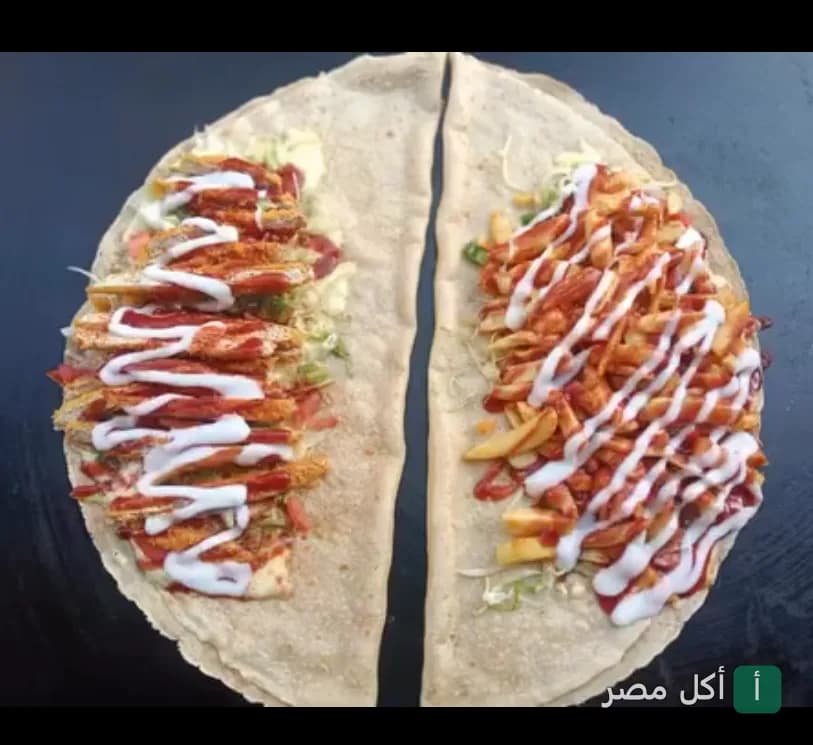 ساندوتش كريب مقسوم نصفين محشو بالبطاطس والدجاج مع صوص الكاتشب والمايونيز من مطعم كابوزيا في إمبابة.