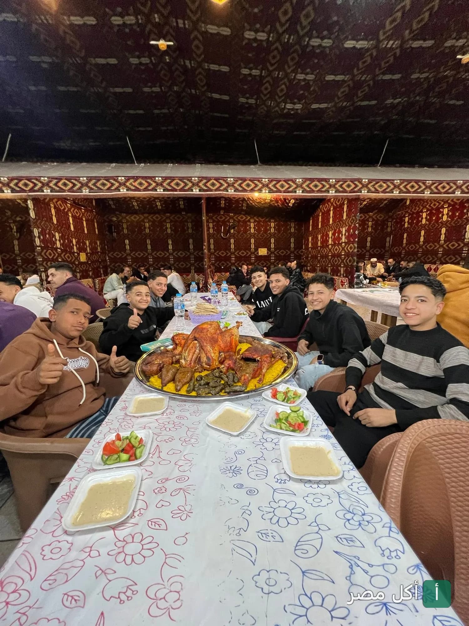 مجموعة أصدقاء يتناولون وليمة كبيرة من الدجاج والمحشي في مطعم الشيخ محمد الكبدة الجملي بكرداسة.