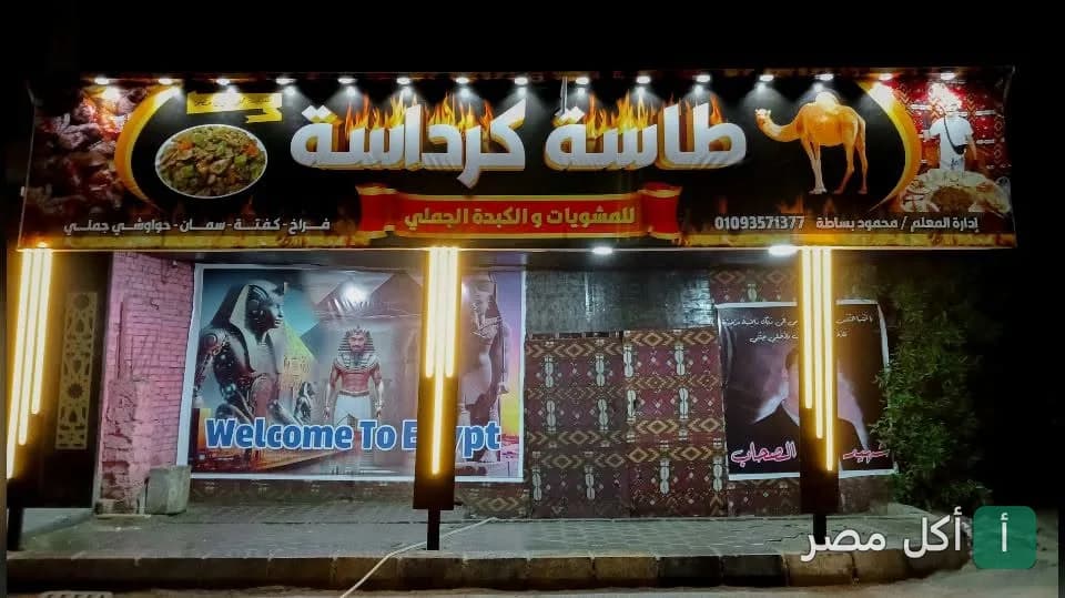 واجهة مطعم طاسة كرداسة للكبدة الجملي في كرداسة ليلاً مع لافتة مضيئة.