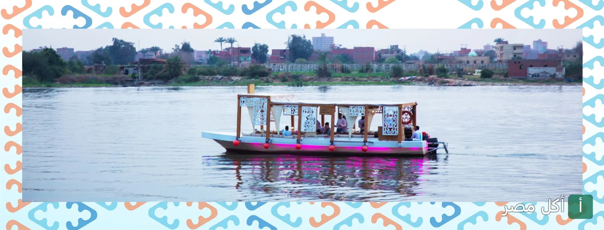 مركب كافيلوكة في نزهة نيلية بمدينة الصف، يظهر بتصميم خشبي أنيق وإضاءة وردية.