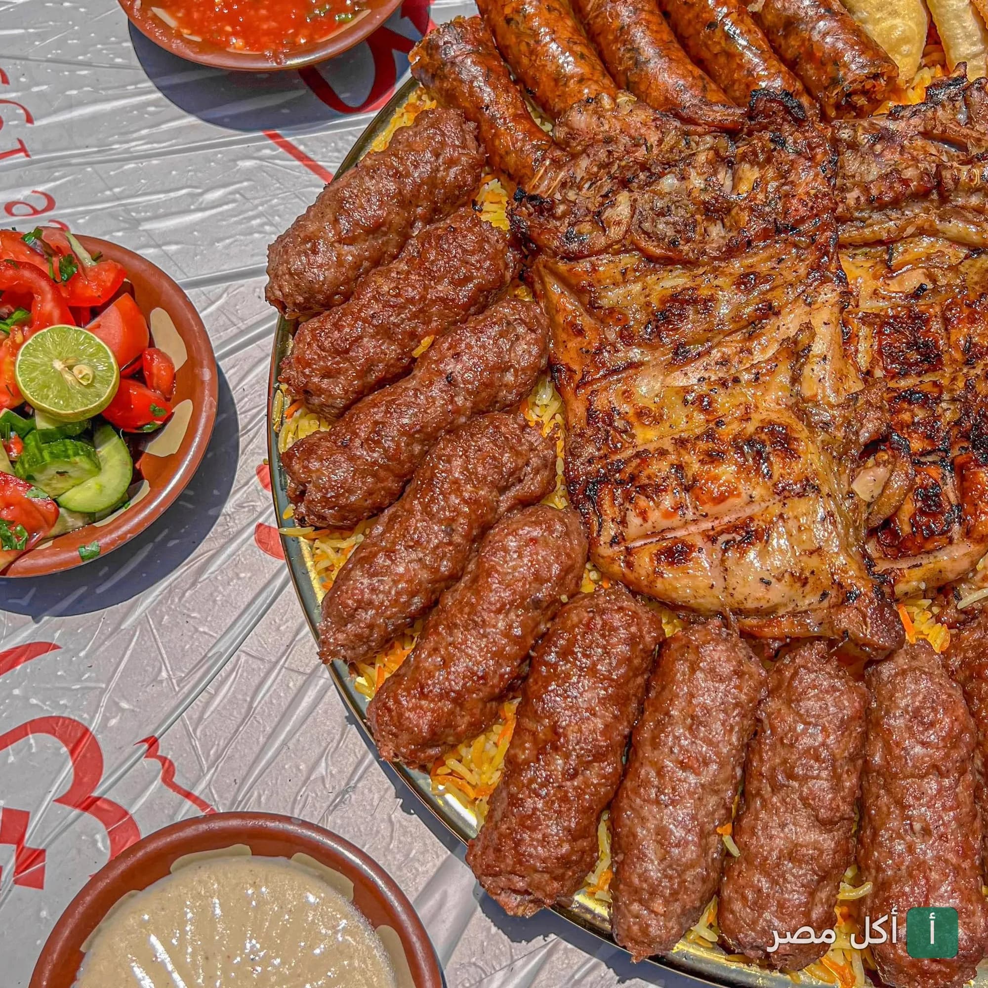 صينية مشويات مشكلة من مطعم الشيخ أبو عمر في الصف، تضم كفتة ودجاج مشوي وممبار مع سلطة وطحينة.