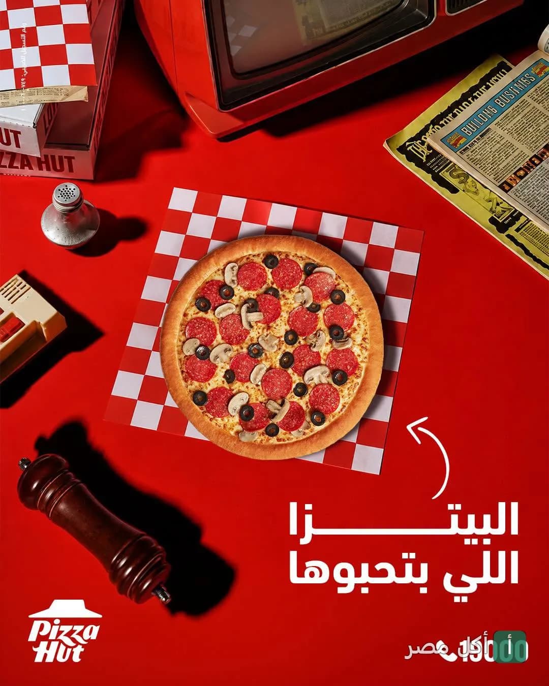 بيتزا بالبيبروني والزيتون والمشروم على مفرش كاروهات أحمر في بيتزا هت الصف.