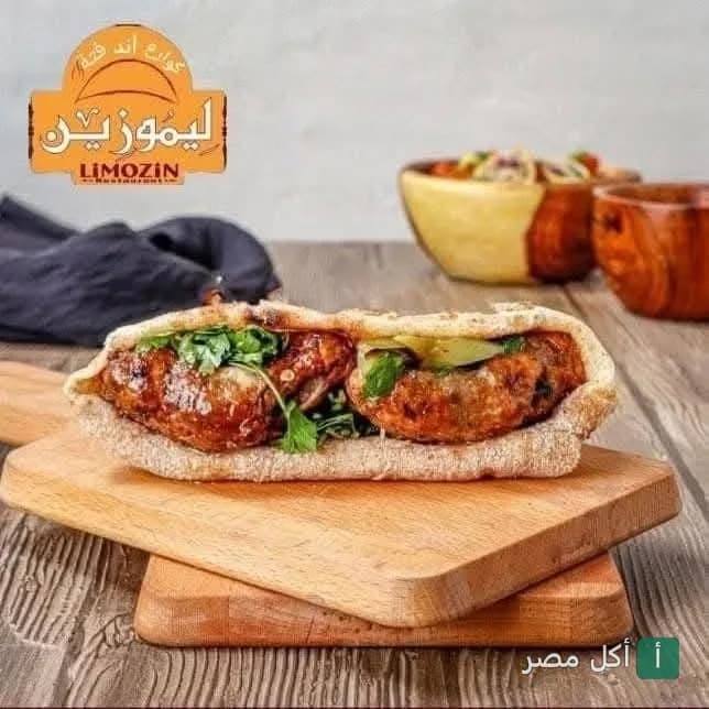 ساندوتش مشويات شرقي في خبز بلدي على لوح تقطيع خشبي في مطعم ليموزين بالصف.