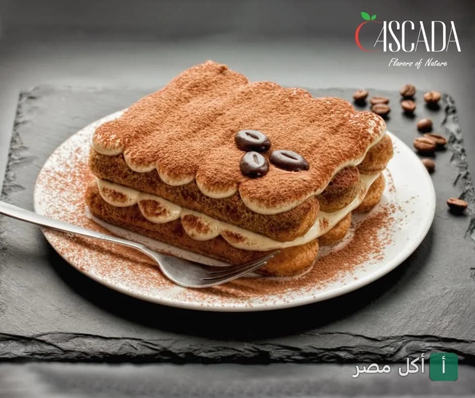 قطعة تيراميسو مزينة بحبوب القهوة على طبق أبيض في مطعم كاسكادا بالصف.
