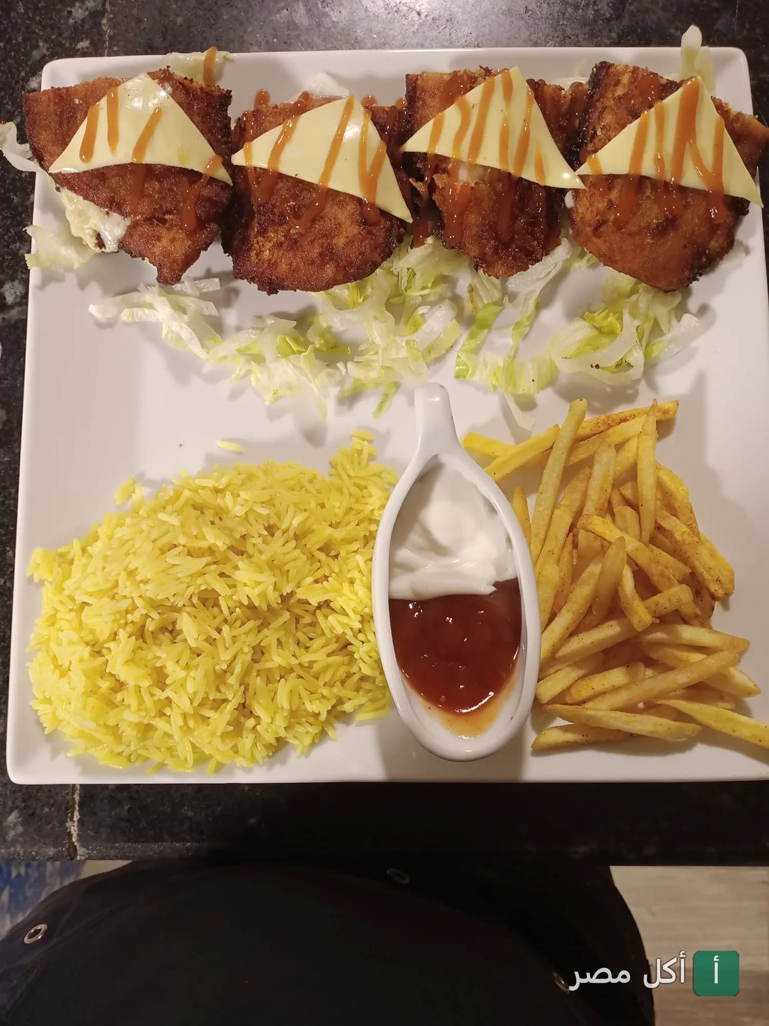 طبق دجاج مقلي مغطى بالجبن مع أرز أصفر وبطاطس مقلية وصوصات في سيلانترو الطيران بالحي السابع.