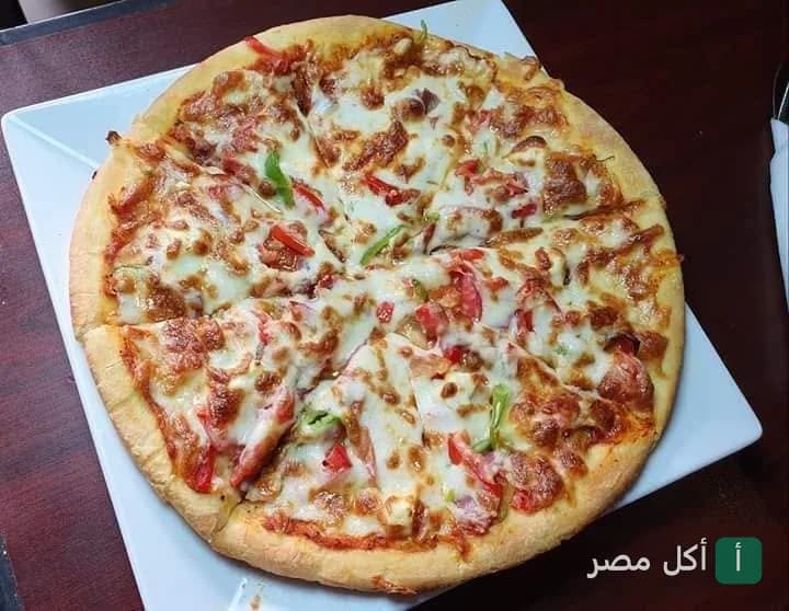 بيتزا بالجبنة والخضروات مقدمة في سيلانترو الطيران بالحي السابع في الصف.