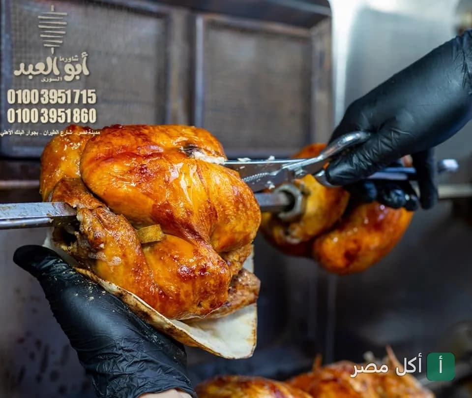 شيف يقطع دجاج الشاورما المشوي من السيخ في مطعم شاورما أبو العبد السوري بالصف.