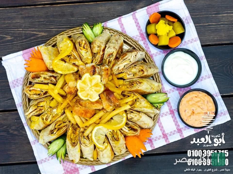 طبق شاورما سوري مقطع مع بطاطس محمرة ومقبلات في مطعم أبو العبد بالصف.