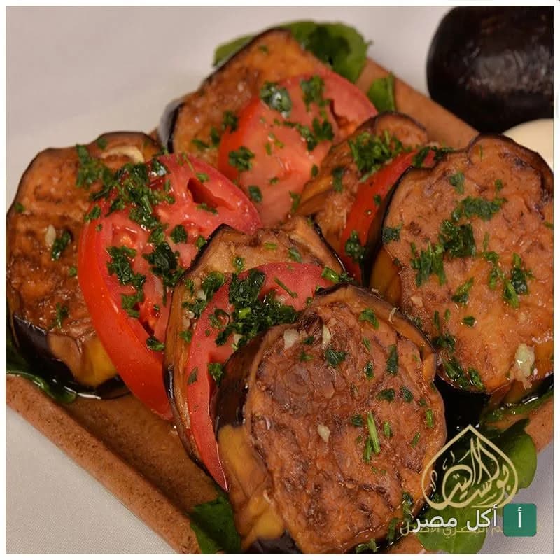طبق باذنجان مقلي مع شرائح طماطم طازجة وبقدونس في مطعم أبو السيد.