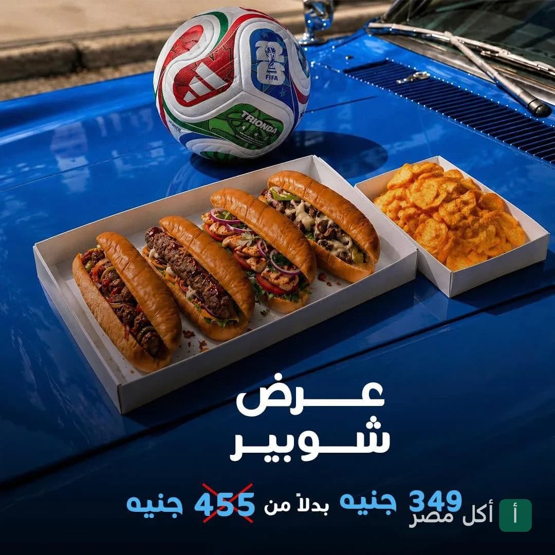 عرض كاسبر في الشيخ زايد يضم مجموعة متنوعة من الساندوتشات مع البطاطس وكرة قدم على غطاء سيارة زرقاء.