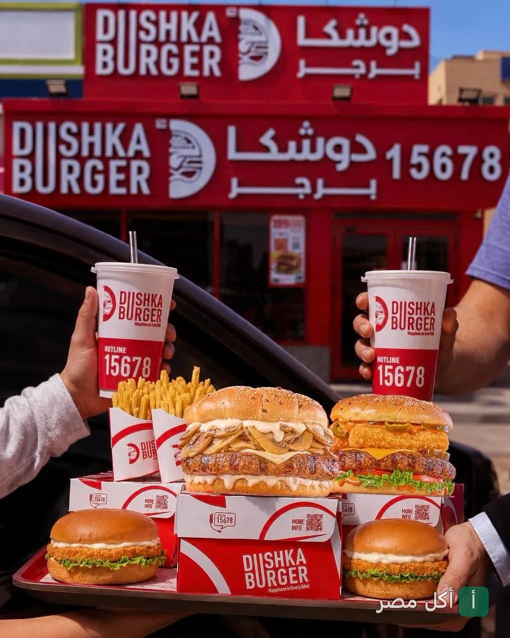صينية وجبات دوشكا برجر مع مشروبات وبطاطس أمام فرع المطعم في الشيخ زايد.