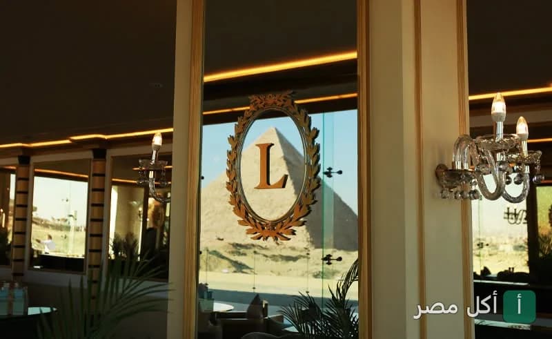 شعار لادوريه داخل إطار ذهبي على نافذة تطل على الأهرامات في فرع أركان بلازا بالشيخ زايد.