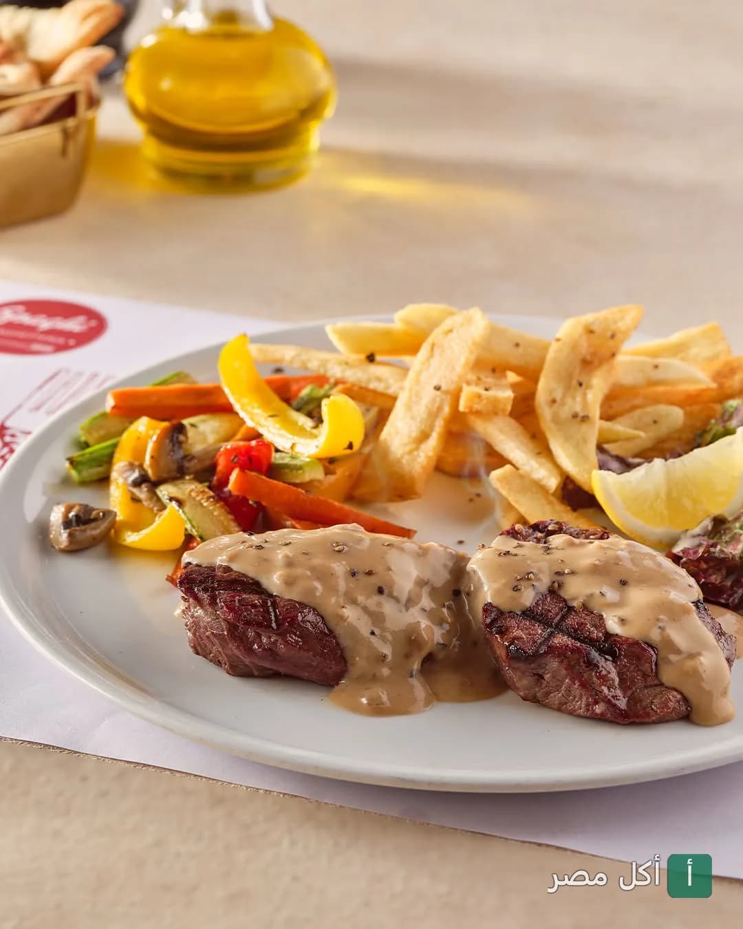 طبق ستيك مشوي بصوص المشروم مع بطاطس مقلية وخضار سوتيه في مطعم سباجي بالشيخ زايد.