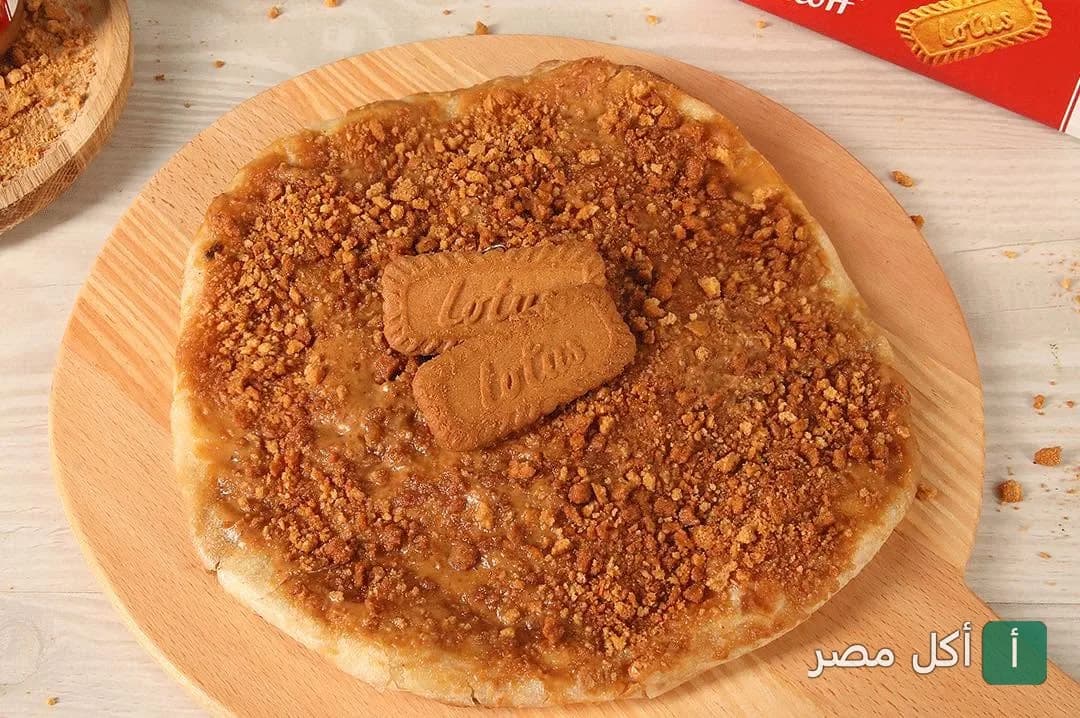 فطيرة حلوة باللوتس وبسكويت اللوتس على لوح تقديم خشبي في مطعم جبنة وعسل بالشيخ زايد